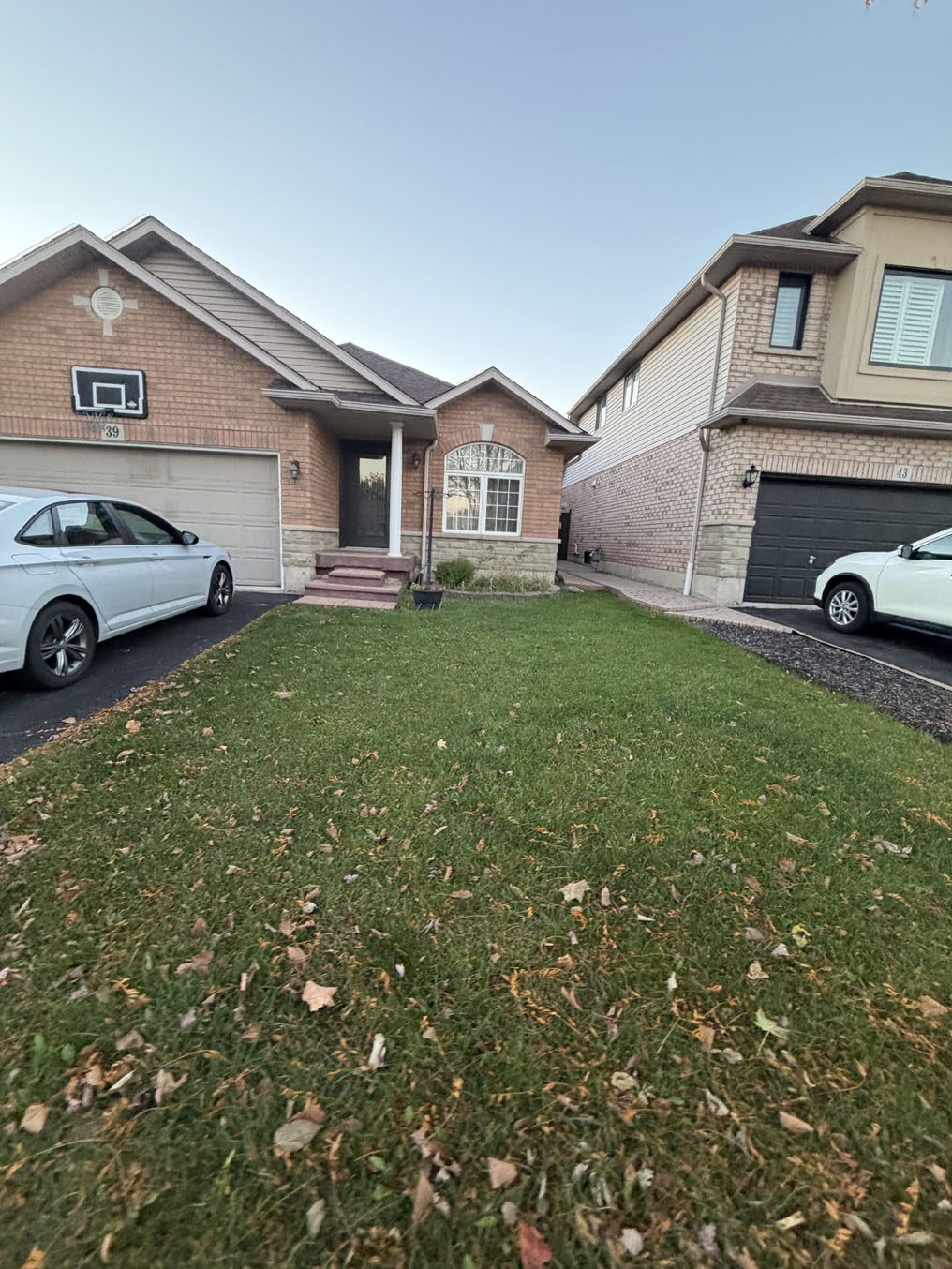 Front lawn between two driveways at a brick bungalow in a Hamilton subdivision