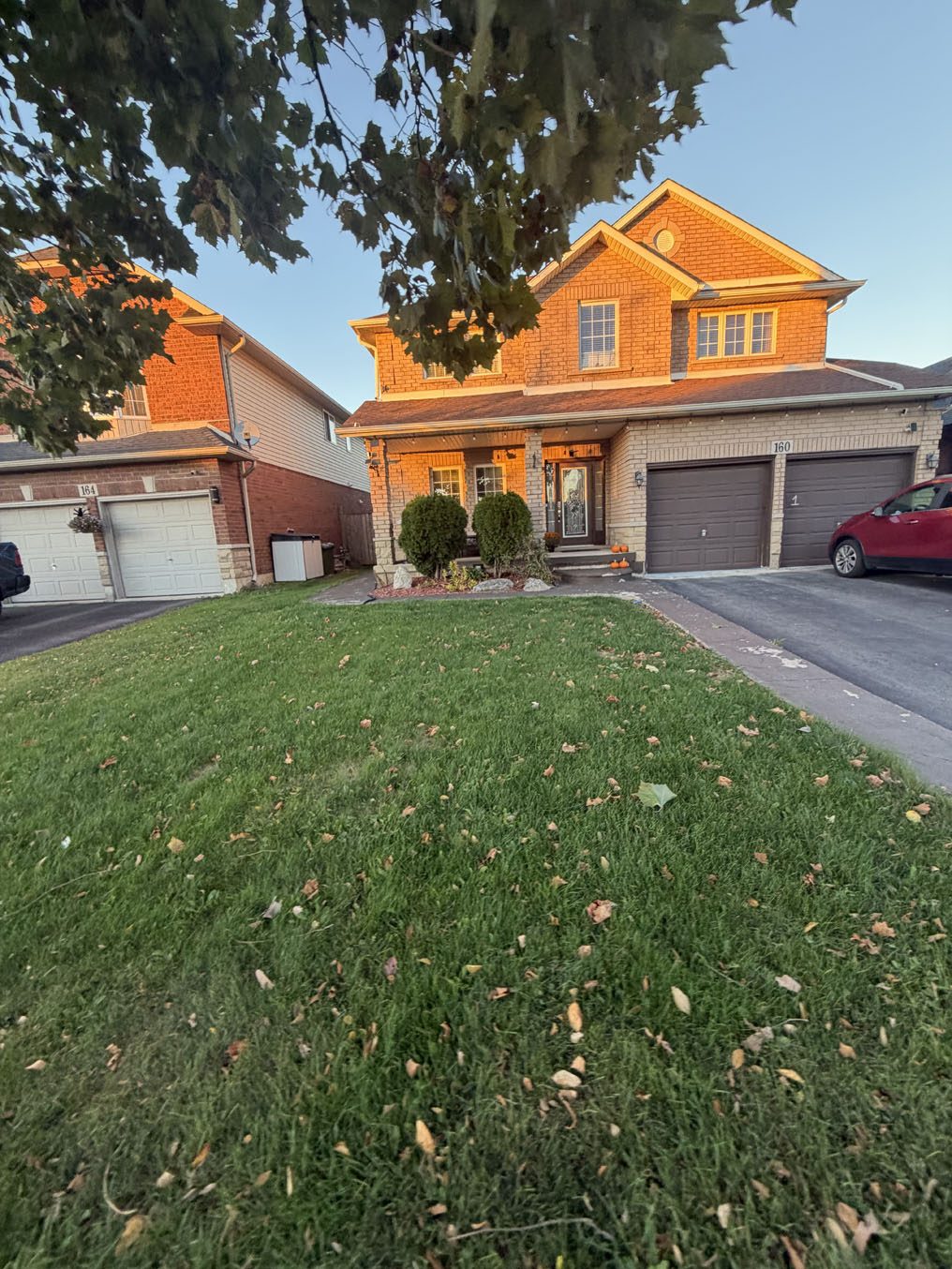 Front lawn glowing in evening light outside a brick home in Hamilton, Ontario