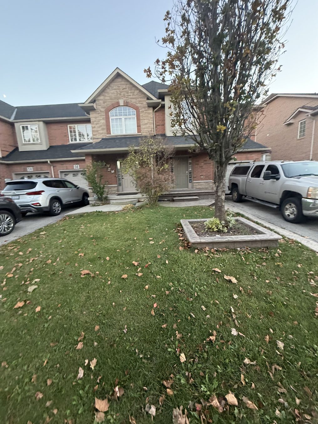 Front lawn with a raised square tree planter at a Hamilton home