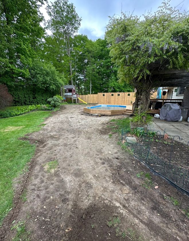 Gallery 22 A residential backyard stripped down to bare dirt around an above-ground pool and deck during a lawn replacement project in Central Burlington, Ontario.