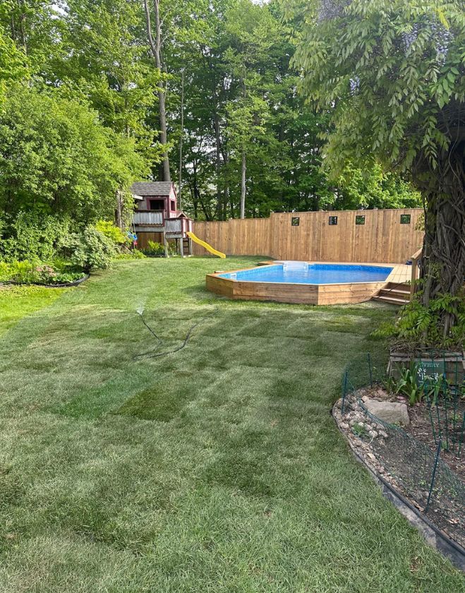 Gallery 24 A beautifully finished backyard featuring freshly installed green sod being watered by a sprinkler around an above-ground pool in Central Burlington, Ontario.