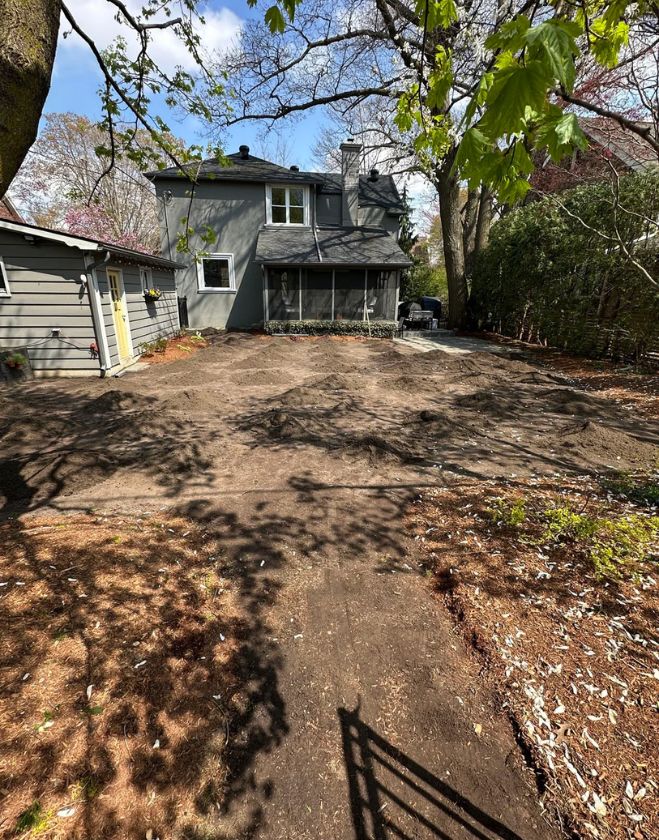 Gallery 11 Small piles of fresh topsoil scattered across a bare dirt backyard, prepared for grading and sod installation in the Beasley neighborhood of Hamilton.