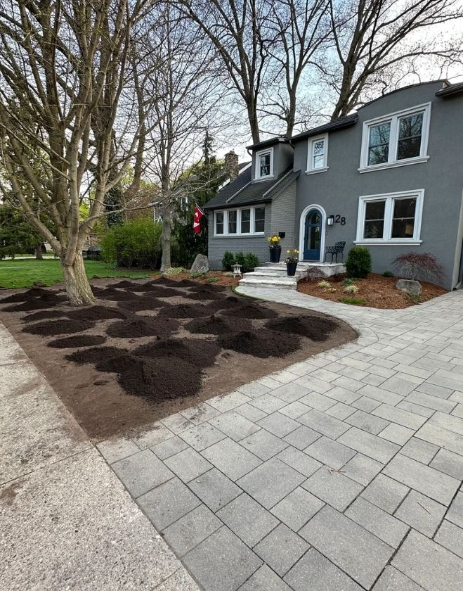 Gallery 15 Piles of fresh, dark topsoil distributed evenly across a bare dirt front yard to prepare for grading and sodding in the North End neighborhood of Hamilton.