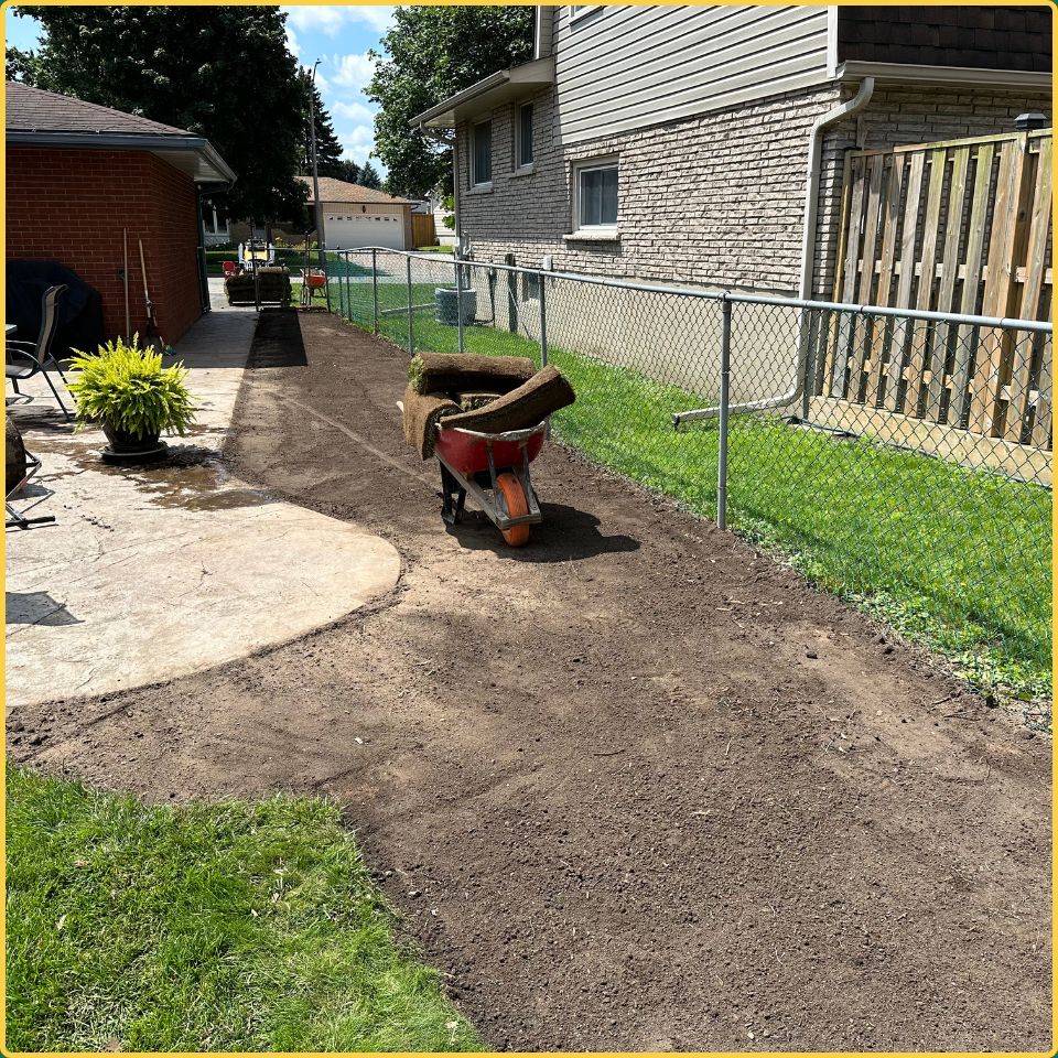 Wheelbarrow loaded with fresh sod rolls for a side yard lawn repair project in Hamilton
