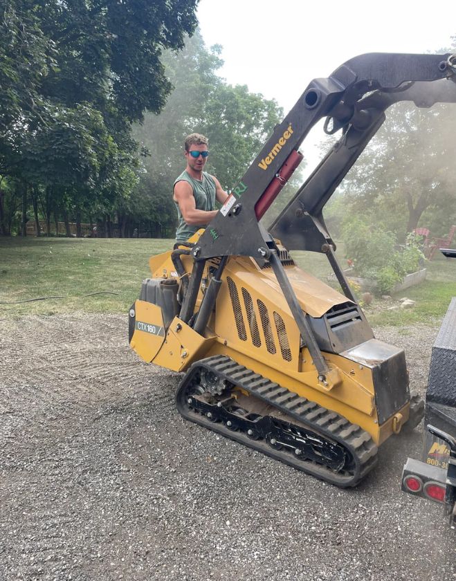 Gallery 32 A professional landscaper operating a yellow Vermeer mini track loader to grade soil and prepare a yard in North Grimsby.
